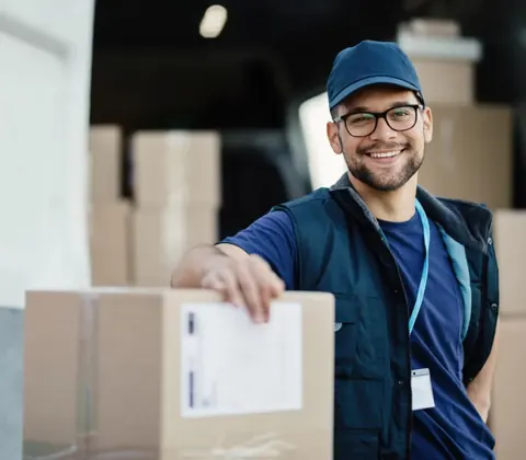 Courier loading a labeled parcel from a delivery van